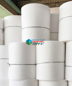 Các cuộn vật liệu trắng lớn được xếp chồng trong kho.