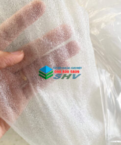 Một mảnh vật liệu cách âm, cách nhiệt màu trắng được tay cầm, có logo và số điện thoại in trên đó.