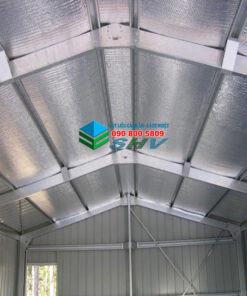 Tấm lợp kim loại bạc cách nhiệt lắp đặt trên khung thép mái dốc trong công trình.