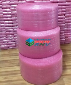 Ba cuộn bong bóng khí màu hồng xếp chồng trên sàn gỗ, có nhiều cuộn khác ở phía sau.