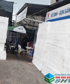 Kho vật liệu xây dựng với các tấm xốp cách âm màu trắng xếp chồng ngoài trời.