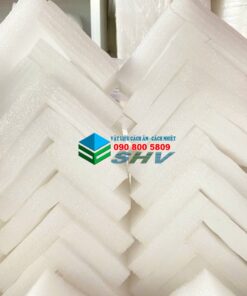 Tam xốp chông sốc hình L, màu trắng, được xếp trong kho.